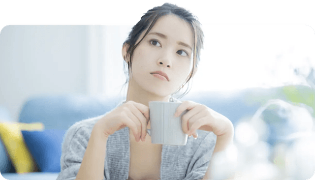 マグカップを持って考える女性